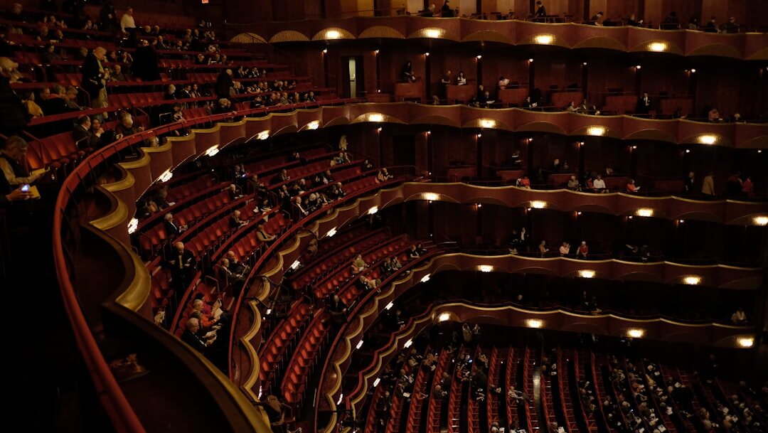 Grand interior of a historic opera house with red velvet seats and gilded balconies