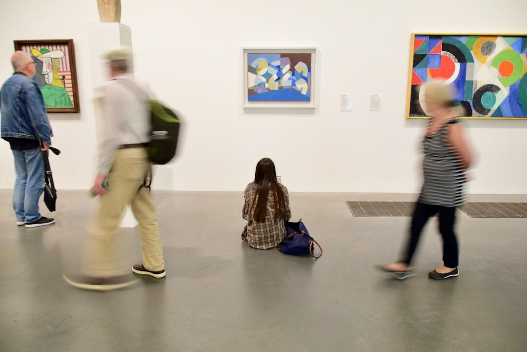 Contemporary art gallery opening with visitors viewing large paintings